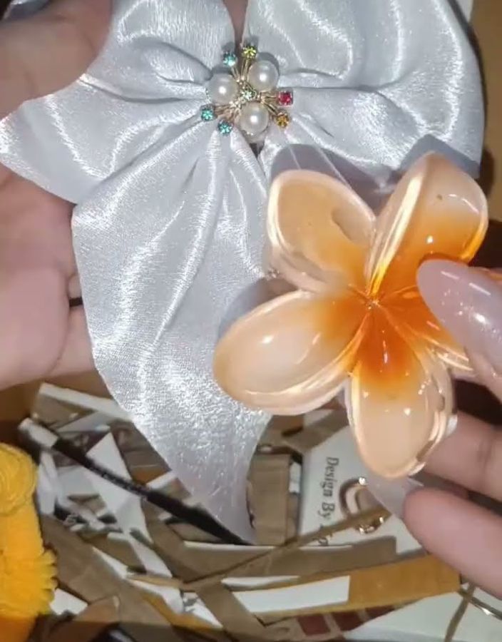 White satin bow with pearl brooch and an orange flower claw clip
