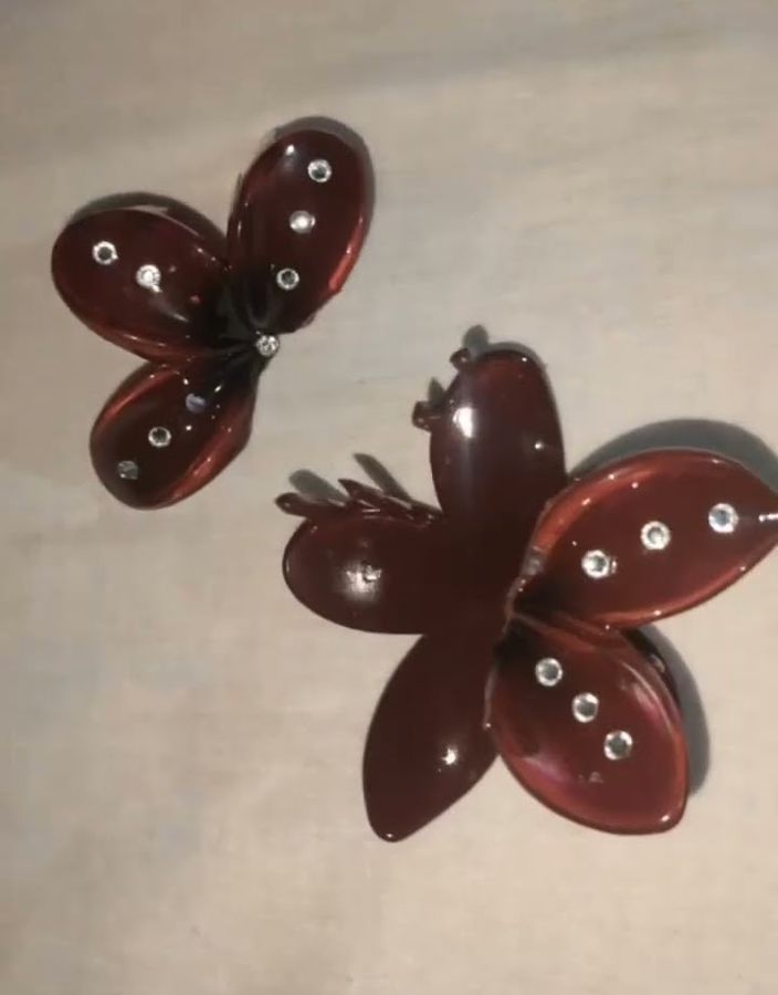 Two maroon butterfly claw clips with rhinestones